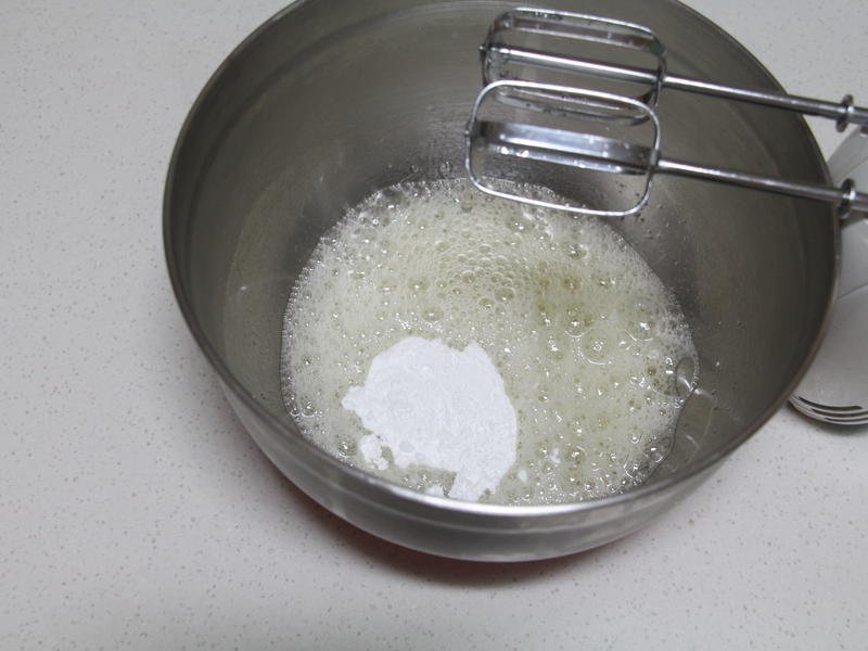 Gradually add powdered sugar to the egg whites